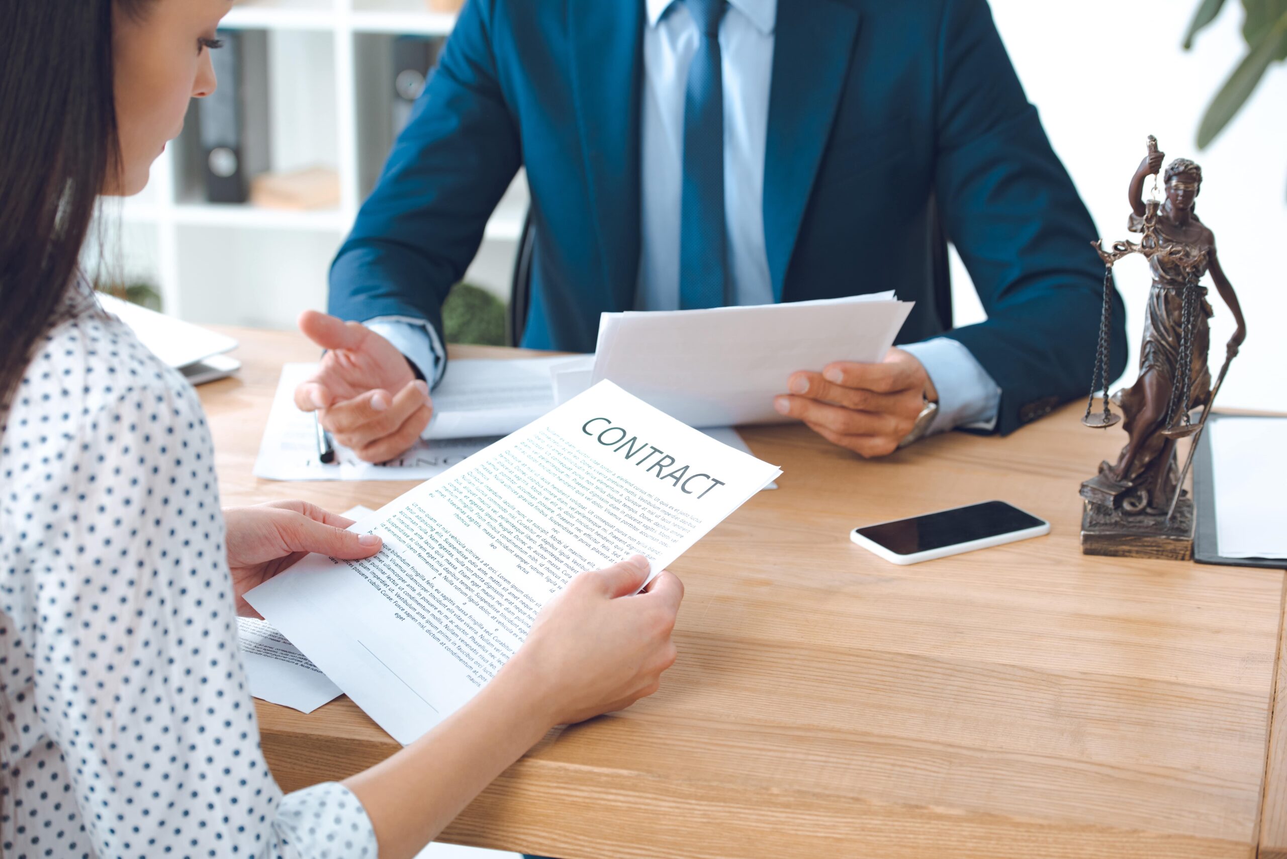 Lawyer holding estate tax contract paper while advising a client