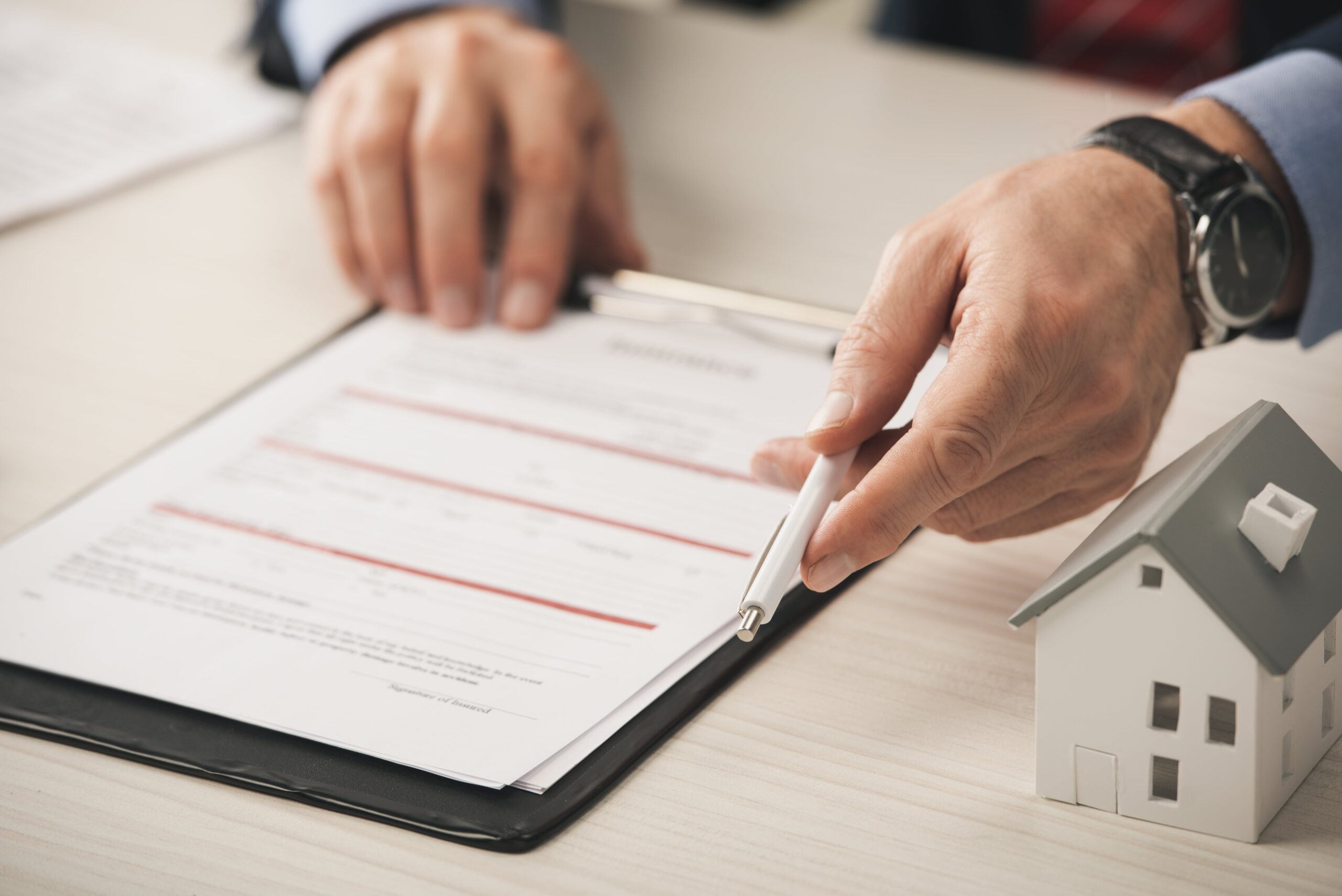 Man reviewing property documents with pen