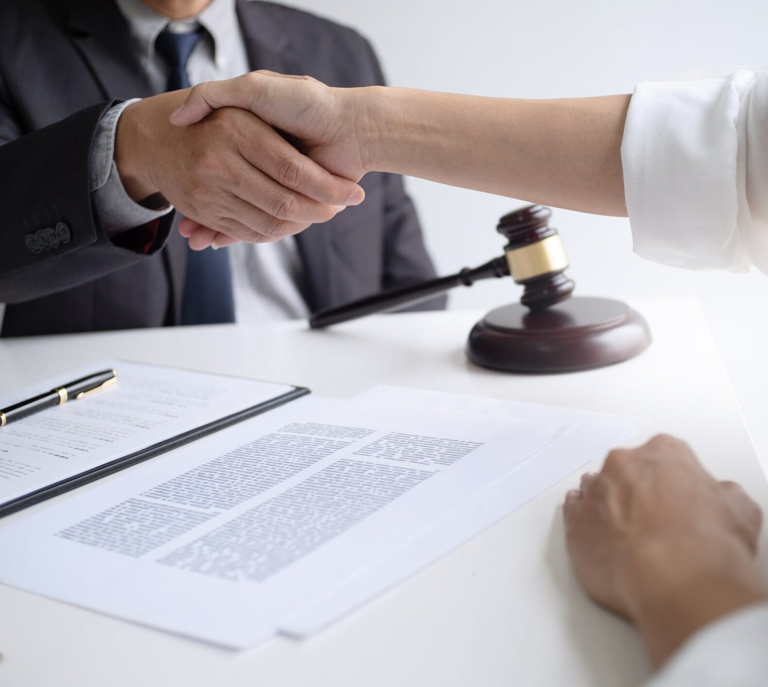 lawyer with client hands shaking in courtroom, legal and justice concept.