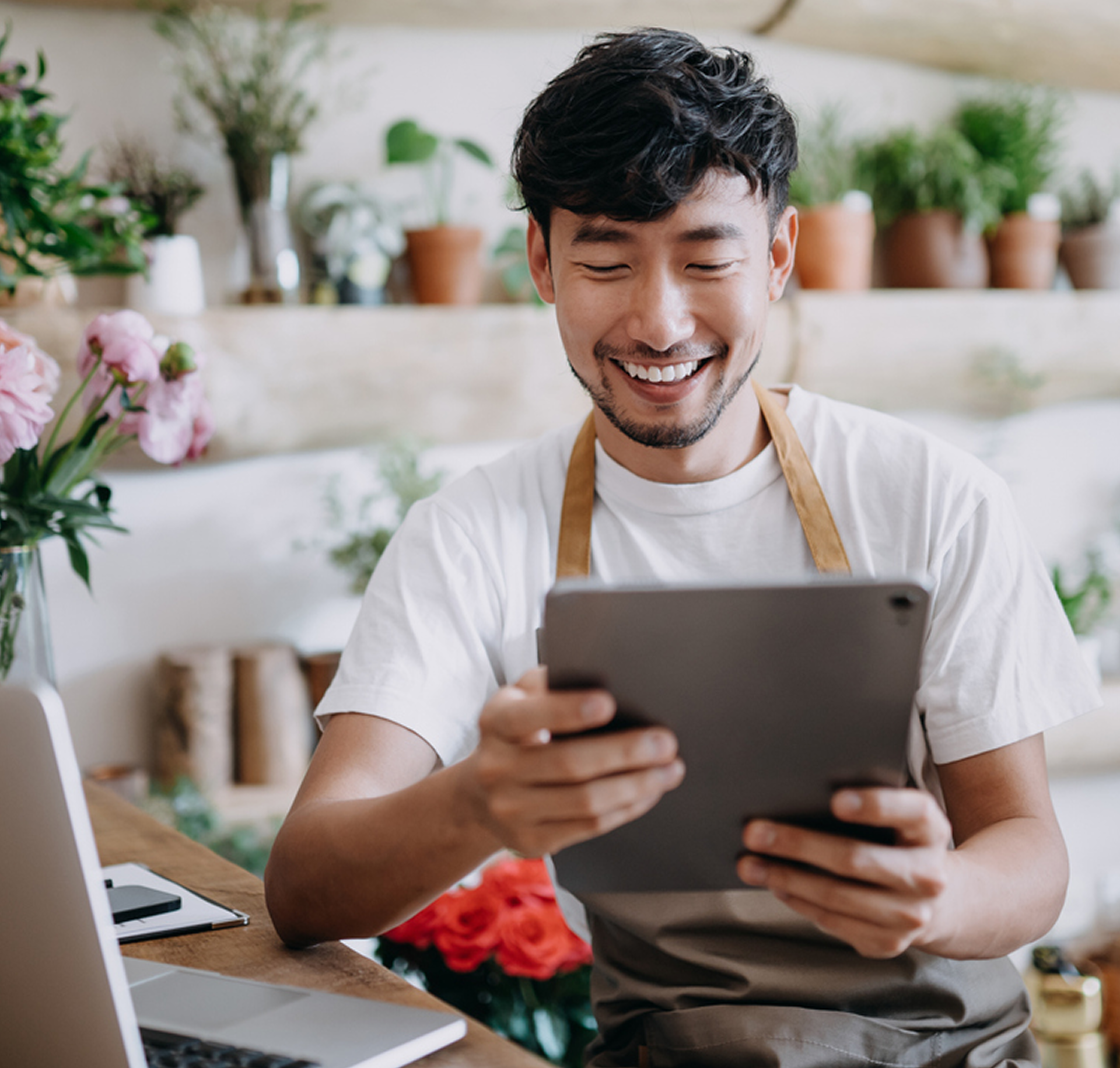 Cheerful startup founder carrying a tablet